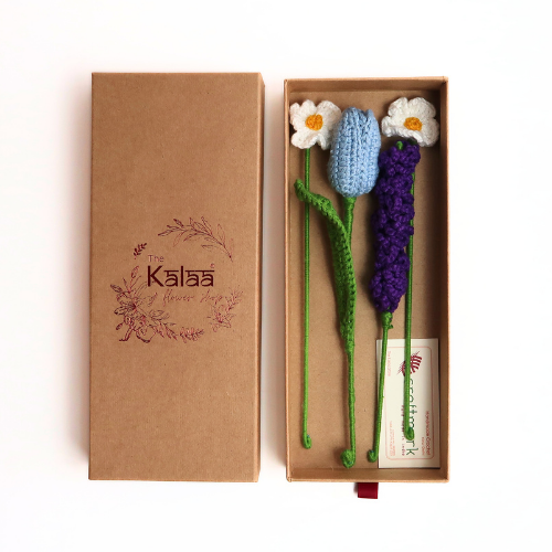 Handcrafted crochet floral arrangement in a gift box, featuring a purple flower and green leaves.